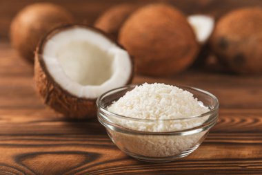 Tahta arka planda taze hindistan cevizi ve dilimler var. Hindistan cevizi gevreği. Vejetaryen. Tropik fındık, meyve. Mesaj için yer. Boşluğu kopyala.