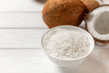 Tahta arka planda taze hindistan cevizi ve dilimler var. Hindistan cevizi gevreği. Vejetaryen. Tropik fındık, meyve. Mesaj için yer. Boşluğu kopyala.