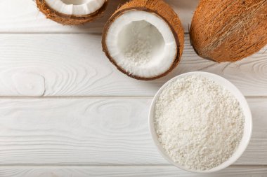 Tahta arka planda taze hindistan cevizi ve dilimler var. Hindistan cevizi gevreği. Vejetaryen. Tropik fındık, meyve. Mesaj için yer. Boşluğu kopyala.