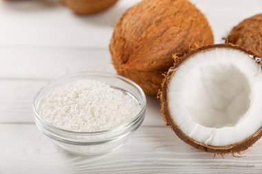 Tahta arka planda taze hindistan cevizi ve dilimler var. Hindistan cevizi gevreği. Vejetaryen. Tropik fındık, meyve. Mesaj için yer. Boşluğu kopyala.