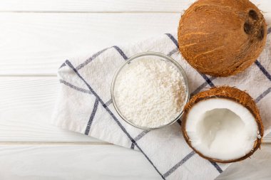 Tahta arka planda taze hindistan cevizi ve dilimler var. Hindistan cevizi gevreği. Vejetaryen. Tropik fındık, meyve. Mesaj için yer. Boşluğu kopyala.