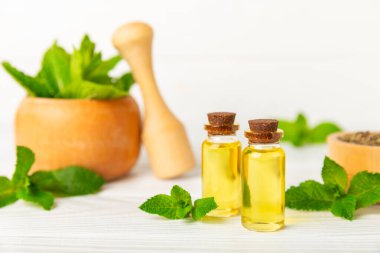 Ahşap bir arka planda esaslı bir nane şekeri. Naneli esaslı yağ ve taze nane yaprakları. Bir şişe aromaterapi yağı. Nane özütü. Doğal kozmetik konsepti, spa bakımı. Boşluğu kopyala