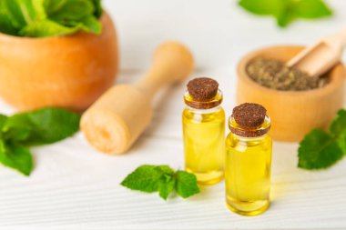 Ahşap bir arka planda esaslı bir nane şekeri. Naneli esaslı yağ ve taze nane yaprakları. Bir şişe aromaterapi yağı. Nane özütü. Doğal kozmetik konsepti, spa bakımı. Boşluğu kopyala