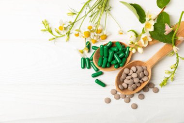 Ahşap zemin üzerinde alternatif ilaç bitkisel kapsül organik ilaç. Bitki ve tablet çeşitleri, vitaminler ve diyet takviyeleri. Sağlıklı yaşam için tıbbi ve şifalı bitkiler.