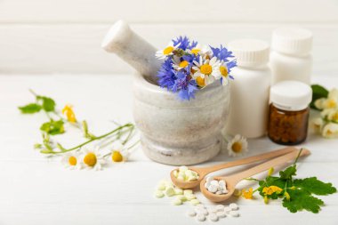 Ahşap zemin üzerinde alternatif ilaç bitkisel kapsül organik ilaç. Bitki ve tablet çeşitleri, vitaminler ve diyet takviyeleri. Sağlıklı yaşam için tıbbi ve şifalı bitkiler.