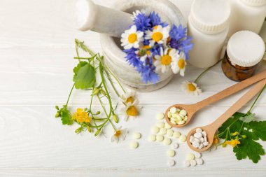 Ahşap zemin üzerinde alternatif ilaç bitkisel kapsül organik ilaç. Bitki ve tablet çeşitleri, vitaminler ve diyet takviyeleri. Sağlıklı yaşam için tıbbi ve şifalı bitkiler.