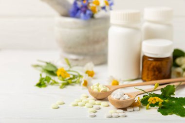 Ahşap zemin üzerinde alternatif ilaç bitkisel kapsül organik ilaç. Bitki ve tablet çeşitleri, vitaminler ve diyet takviyeleri. Sağlıklı yaşam için tıbbi ve şifalı bitkiler.