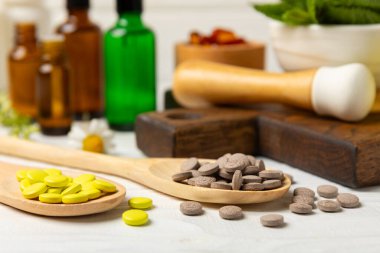 Ahşap zemin üzerinde alternatif ilaç bitkisel kapsül organik ilaç. Bitki ve tablet çeşitleri, vitaminler ve diyet takviyeleri. Sağlıklı yaşam için tıbbi ve şifalı bitkiler.