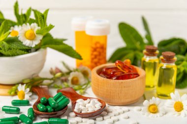 Ahşap zemin üzerinde alternatif ilaç bitkisel kapsül organik ilaç. Bitki ve tablet çeşitleri, vitaminler ve diyet takviyeleri. Sağlıklı yaşam için tıbbi ve şifalı bitkiler.