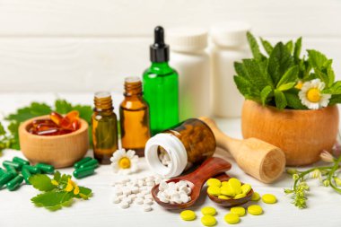 Ahşap zemin üzerinde alternatif ilaç bitkisel kapsül organik ilaç. Bitki ve tablet çeşitleri, vitaminler ve diyet takviyeleri. Sağlıklı yaşam için tıbbi ve şifalı bitkiler.