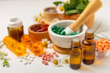 Ahşap zemin üzerinde alternatif ilaç bitkisel kapsül organik ilaç. Bitki ve tablet çeşitleri, vitaminler ve diyet takviyeleri. Sağlıklı yaşam için tıbbi ve şifalı bitkiler.