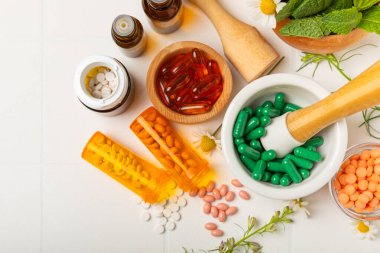Ahşap zemin üzerinde alternatif ilaç bitkisel kapsül organik ilaç. Bitki ve tablet çeşitleri, vitaminler ve diyet takviyeleri. Sağlıklı yaşam için tıbbi ve şifalı bitkiler.