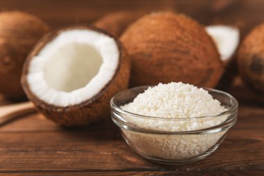 Tahta arka planda taze hindistan cevizi ve dilimler var. Hindistan cevizi gevreği. Vejetaryen. Tropik fındık, meyve. Mesaj için yer. Boşluğu kopyala.