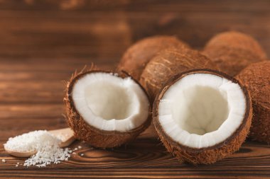 Tahta arka planda taze hindistan cevizi ve dilimler var. Hindistan cevizi gevreği. Vejetaryen. Tropik fındık, meyve. Mesaj için yer. Boşluğu kopyala.