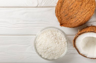 Tahta arka planda taze hindistan cevizi ve dilimler var. Hindistan cevizi gevreği. Vejetaryen. Tropik fındık, meyve. Mesaj için yer. Boşluğu kopyala.