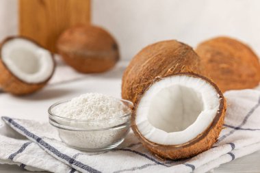 Tahta arka planda taze hindistan cevizi ve dilimler var. Hindistan cevizi gevreği. Vejetaryen. Tropik fındık, meyve. Mesaj için yer. Boşluğu kopyala.