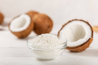 Tahta arka planda taze hindistan cevizi ve dilimler var. Hindistan cevizi gevreği. Vejetaryen. Tropik fındık, meyve. Mesaj için yer. Boşluğu kopyala.