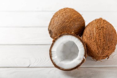 Tahta arka planda taze hindistan cevizi ve dilimler var. Hindistan cevizi gevreği. Vejetaryen. Tropik fındık, meyve. Mesaj için yer. Boşluğu kopyala.