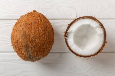 Tahta arka planda taze hindistan cevizi ve dilimler var. Hindistan cevizi gevreği. Vejetaryen. Tropik fındık, meyve. Mesaj için yer. Boşluğu kopyala.