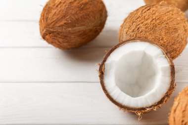 Tahta arka planda taze hindistan cevizi ve dilimler var. Hindistan cevizi gevreği. Vejetaryen. Tropik fındık, meyve. Mesaj için yer. Boşluğu kopyala.