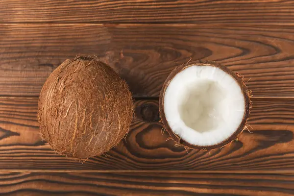 Tahta arka planda taze hindistan cevizi ve dilimler var. Hindistan cevizi gevreği. Vejetaryen. Tropik fındık, meyve. Mesaj için yer. Boşluğu kopyala.