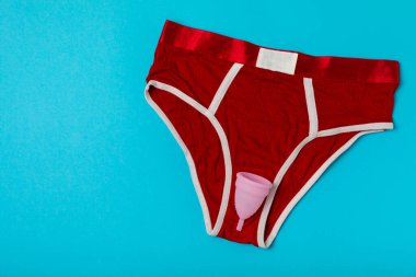 Aybaşı bardağı parlak bir arka planda. Hijyenik peçeteler, tamponlar ve regl kupası. Kritik günler, regl dönemi kavramı. Kadın hijyen ürünü. Kadın sağlığı kavramı. Adet öncesi sendromu. Boşluğu kopyala