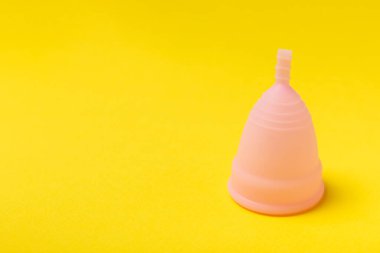 Aybaşı bardağı parlak bir arka planda. Hijyenik peçeteler, tamponlar ve regl kupası. Kritik günler, regl dönemi kavramı. Kadın hijyen ürünü. Kadın sağlığı kavramı. Adet öncesi sendromu. Boşluğu kopyala