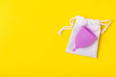 Aybaşı bardağı parlak bir arka planda. Hijyenik peçeteler, tamponlar ve regl kupası. Kritik günler, regl dönemi kavramı. Kadın hijyen ürünü. Kadın sağlığı kavramı. Adet öncesi sendromu. Boşluğu kopyala