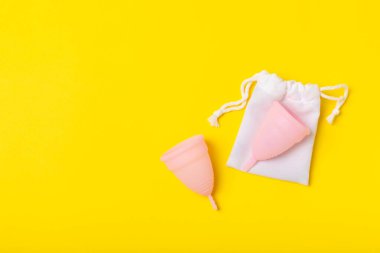 Aybaşı bardağı parlak bir arka planda. Hijyenik peçeteler, tamponlar ve regl kupası. Kritik günler, regl dönemi kavramı. Kadın hijyen ürünü. Kadın sağlığı kavramı. Adet öncesi sendromu. Boşluğu kopyala