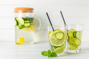 Salatalık suyu, limon, nane ve ahşap bir masada. İçme bardağında dilimlenmiş salatalık ile karıştırılmış su. Tonik ferahlatıcı bir içecek. Salatalık limonata. Doğal soğutma içeceği. Boşluğu kopyala.