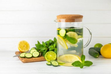 Salatalık suyu, limon, nane ve ahşap bir masada. İçme bardağında dilimlenmiş salatalık ile karıştırılmış su. Tonik ferahlatıcı bir içecek. Salatalık limonata. Doğal soğutma içeceği. Boşluğu kopyala.