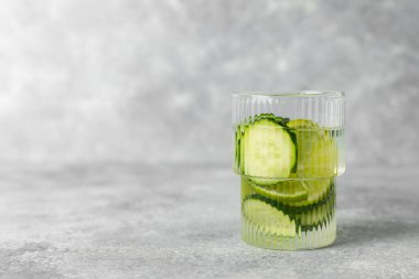 Salatalık suyu, limon, nane ve ahşap bir masada. İçme bardağında dilimlenmiş salatalık ile karıştırılmış su. Tonik ferahlatıcı bir içecek. Salatalık limonata. Doğal soğutma içeceği. Boşluğu kopyala.