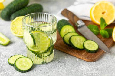 Salatalık suyu, limon, nane ve ahşap bir masada. İçme bardağında dilimlenmiş salatalık ile karıştırılmış su. Tonik ferahlatıcı bir içecek. Salatalık limonata. Doğal soğutma içeceği. Boşluğu kopyala.