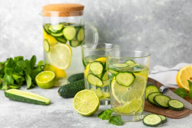 Salatalık suyu, limon, nane ve ahşap bir masada. İçme bardağında dilimlenmiş salatalık ile karıştırılmış su. Tonik ferahlatıcı bir içecek. Salatalık limonata. Doğal soğutma içeceği. Boşluğu kopyala.
