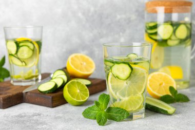 Salatalık suyu, limon, nane ve ahşap bir masada. İçme bardağında dilimlenmiş salatalık ile karıştırılmış su. Tonik ferahlatıcı bir içecek. Salatalık limonata. Doğal soğutma içeceği. Boşluğu kopyala.