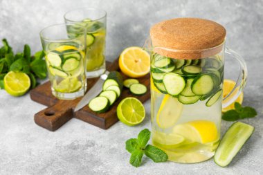 Salatalık suyu, limon, nane ve ahşap bir masada. İçme bardağında dilimlenmiş salatalık ile karıştırılmış su. Tonik ferahlatıcı bir içecek. Salatalık limonata. Doğal soğutma içeceği. Boşluğu kopyala.