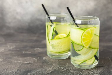 Salatalık suyu, limon, nane ve ahşap bir masada. İçme bardağında dilimlenmiş salatalık ile karıştırılmış su. Tonik ferahlatıcı bir içecek. Salatalık limonata. Doğal soğutma içeceği. Boşluğu kopyala.