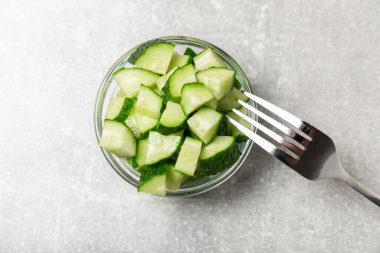 Ahşap arka planda salatalık. Arka planda bir parça salatalık. Taze organik yeşil salatalık turşusu. Vejetaryen. Salata malzemesi. Çiftlik sebzeleri. Sebzeleri bıçakla kes. Mesaj için yer var. Boşluğu kopyala