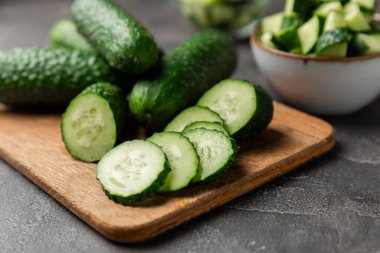 Ahşap arka planda salatalık. Arka planda bir parça salatalık. Taze organik yeşil salatalık turşusu. Vejetaryen. Salata malzemesi. Çiftlik sebzeleri. Sebzeleri bıçakla kes. Mesaj için yer var. Boşluğu kopyala