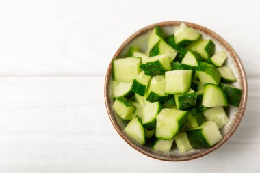 Ahşap arka planda salatalık. Arka planda bir parça salatalık. Taze organik yeşil salatalık turşusu. Vejetaryen. Salata malzemesi. Çiftlik sebzeleri. Sebzeleri bıçakla kes. Mesaj için yer var. Boşluğu kopyala