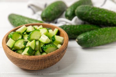 Ahşap arka planda salatalık. Arka planda bir parça salatalık. Taze organik yeşil salatalık turşusu. Vejetaryen. Salata malzemesi. Çiftlik sebzeleri. Sebzeleri bıçakla kes. Mesaj için yer var. Boşluğu kopyala