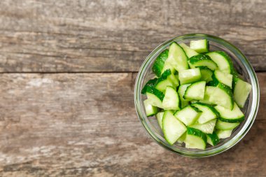 Ahşap arka planda salatalık. Arka planda bir parça salatalık. Taze organik yeşil salatalık turşusu. Vejetaryen. Salata malzemesi. Çiftlik sebzeleri. Sebzeleri bıçakla kes. Mesaj için yer var. Boşluğu kopyala