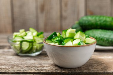 Ahşap arka planda salatalık. Arka planda bir parça salatalık. Taze organik yeşil salatalık turşusu. Vejetaryen. Salata malzemesi. Çiftlik sebzeleri. Sebzeleri bıçakla kes. Mesaj için yer var. Boşluğu kopyala