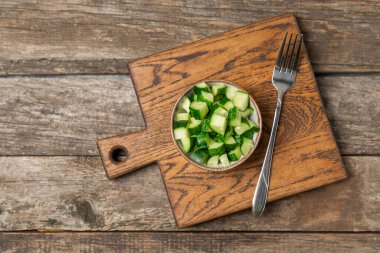 Ahşap arka planda salatalık. Arka planda bir parça salatalık. Taze organik yeşil salatalık turşusu. Vejetaryen. Salata malzemesi. Çiftlik sebzeleri. Sebzeleri bıçakla kes. Mesaj için yer var. Boşluğu kopyala