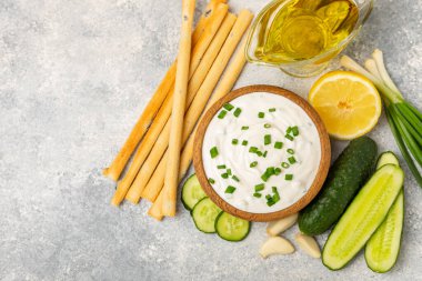 Ahşap bir masada salatalık kremalı tzatziki sosu. Tatar sosu. Geleneksel lezzetli aperatif. Yoğurt sosu. Tzatziki, salatalık, sarımsak, dereotu, limon, nane. Salata sosu. Kopya alanı.
