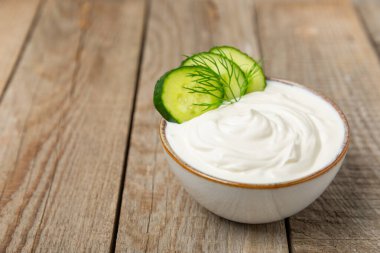 Ahşap bir masada salatalık kremalı tzatziki sosu. Tatar sosu. Geleneksel lezzetli aperatif. Yoğurt sosu. Tzatziki, salatalık, sarımsak, dereotu, limon, nane. Salata sosu. Kopya alanı.