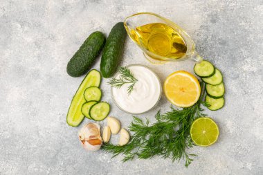 Ahşap bir masada salatalık kremalı tzatziki sosu. Tatar sosu. Geleneksel lezzetli aperatif. Yoğurt sosu. Tzatziki, salatalık, sarımsak, dereotu, limon, nane. Salata sosu. Kopya alanı.