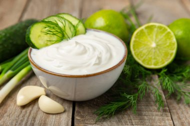 Ahşap bir masada salatalık kremalı tzatziki sosu. Tatar sosu. Geleneksel lezzetli aperatif. Yoğurt sosu. Tzatziki, salatalık, sarımsak, dereotu, limon, nane. Salata sosu. Kopya alanı.