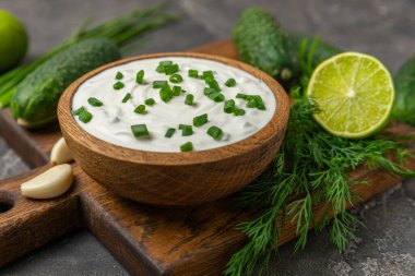 Ahşap bir masada salatalık kremalı tzatziki sosu. Tatar sosu. Geleneksel lezzetli aperatif. Yoğurt sosu. Tzatziki, salatalık, sarımsak, dereotu, limon, nane. Salata sosu. Kopya alanı.