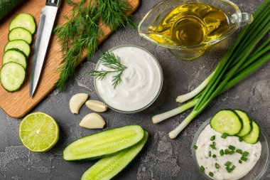 Ahşap bir masada salatalık kremalı tzatziki sosu. Tatar sosu. Geleneksel lezzetli aperatif. Yoğurt sosu. Tzatziki, salatalık, sarımsak, dereotu, limon, nane. Salata sosu. Kopya alanı.
